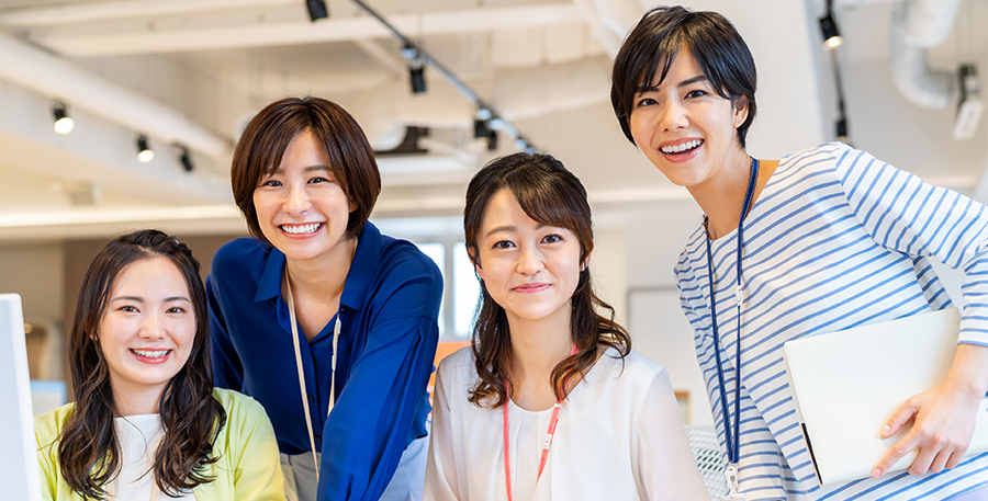 女性社員4人が並んでる写真